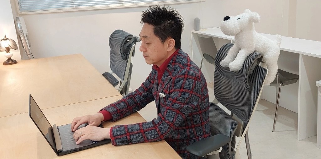 オフィスでパソコンに向かう代表理事・谷厚志